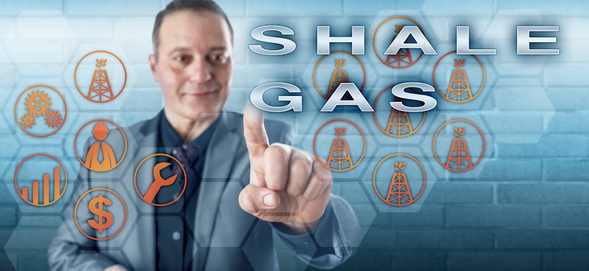 Cheerful industrial manager with toothless smile pushing SHALE GAS on an interactive control screen. Fossil fuel metaphor and energy industry concept for natural gas production from shale formations.