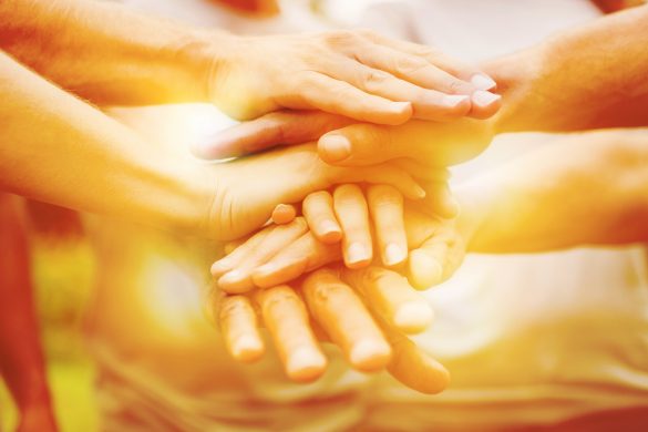 Happy volunteer family putting their hands together