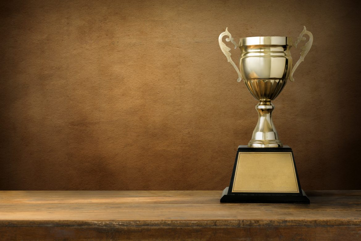 champion golden trophy on wood table with blackboard copy space